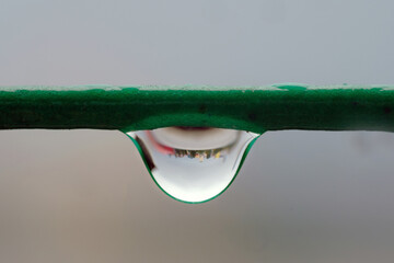 Close up of water drop on the rope reflecting cityscape, soft focus