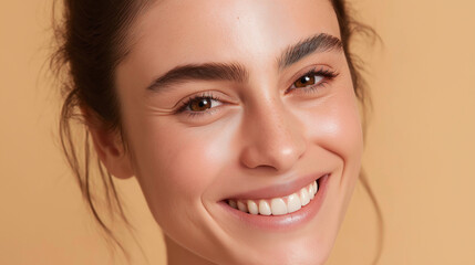 Obraz premium Close up of radiant cheeks with sun kissed warmth and natural glowing skin, smiling young woman with brown eyes and dark hair against beige background