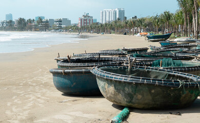  Traditional Vietnamese basket boats on sandy beach. High quality photo (coracle boats) Local fishing equipment and coastal lifestyle in Vietnam, Southeast Asia. No people, outdoor daytime scene. 
