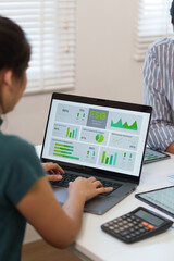 Business professional analyzing an ESG performance dashboard with data charts and metrics on a...