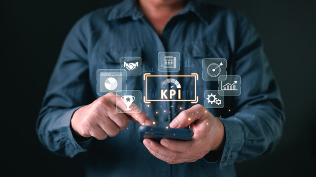 Businessman using smartphone with virtual KPI dashboard. Concept of key performance indicator, business analysis, digital data metrics, financial growth and corporate success strategy. - Powered by Adobe