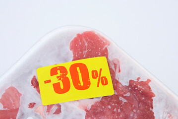 Raw meat in package with discount label