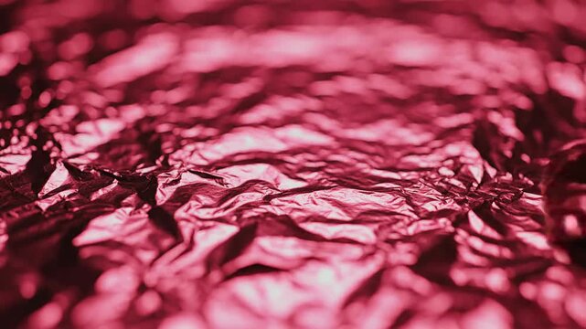 Abstract close up of wrinkled metallic surface in red tones