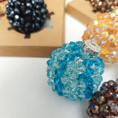 Collection of elegant handmade Christmas balls made of crystal  beads of different colors. Festive holiday decorations displayed in gift boxes . Luxury winter decor concept