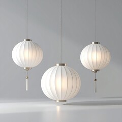 Three white paper lanterns with gold accents and tassels hang illuminated against a soft gray studio background ideal for ambient lighting and decorative purposes