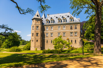 Historic castle surrounded by green park landscape in Goluchow, Poland.