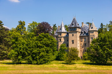 Historic castle surrounded by green park landscape in Goluchow, Poland.