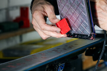 Ski maintenance and repair. Applying hot melted wax on the ski base surface