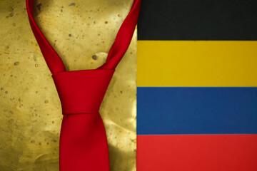 Red necktie symbol of America, president's signature look. Grunge gold and black colors, as oil black gold. National colors of Venezuela flag. Shallow depth of field.