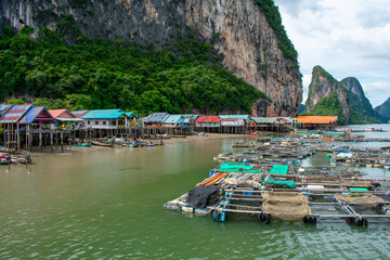 Koh Panyi floating Muslim village in Thailand. Boats and limestone rock formations on Andaman Sea, Phi Phi islands 