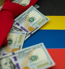 Blur randomly placed US dollars and a red necktie on the national colors of the Venezuelan flag background. The black color on top symbolizes the country's black gold.