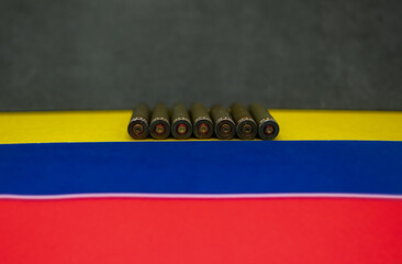 Row of bullet casings on the national colors of the Venezuelan flag. Metaphorical view of the political instability and international relations in South America. Copy space.