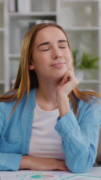 Dreamy smiling young girl studying online from home on laptop and thinking or day dreaming with smile on her face. Female executive dreaming at workplace with computer. Slow motion.