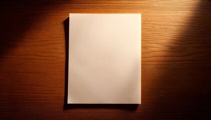 Blank white paper on a wooden table with sunlight shadow.