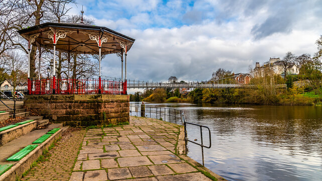 A view past a bandstand towards the Queens Park bridge beside the River Dee in the city of Chester, Cheshire, UK