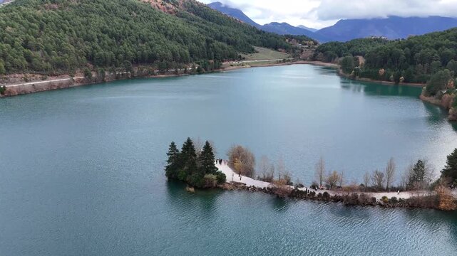 Aerial orbit shot of Agios Fanourios church in the middle of Lake Doxa, Peloponnese, Greece