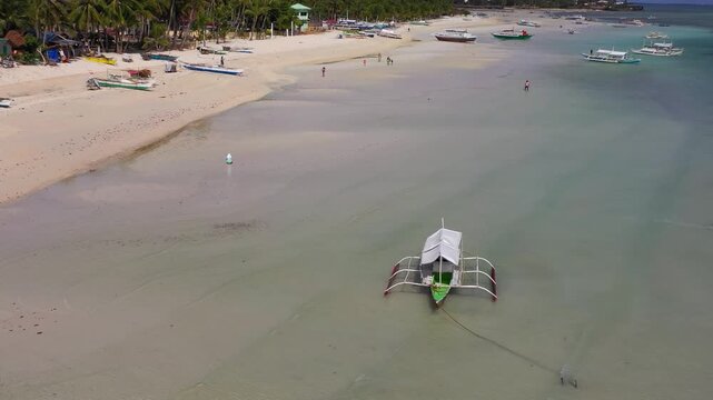 Aerial view of tidal flats with people walking in shallow water