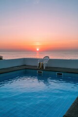 Serene ocean view at sunrise by the poolside.