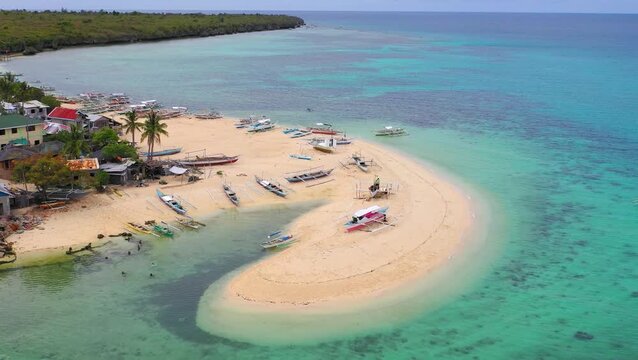 Aerial view of sandbar with umbrellas and boats in shallow water