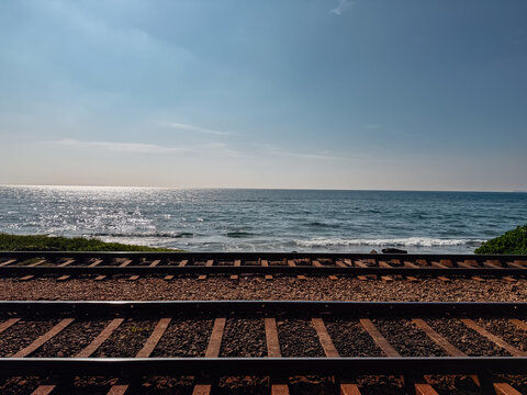 Scenic railway tracks running parallel to the shimmering Indian Ocean coast in Sri Lanka