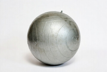 Metal ball used in outdoor games and sports activities often seen in parks and yards during gatherings and leisure time with friends or family