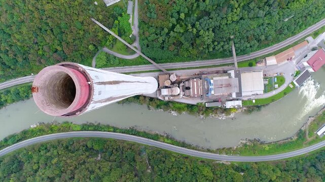 Aerial view of industrial chimney top with river and landscape