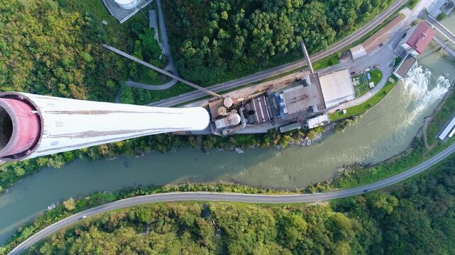 Aerial view of industrial complex and chimney beside river