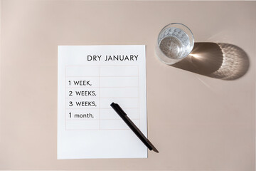 "Dry January" Tracking Sheet with Pen and Water Glass on Beige Surface Promoting Alcohol-Free Commitment and Wellness   generative ai