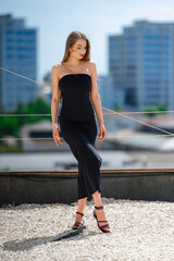 Strapless Caucasian Model On Rooftop Skyline, Black Dress Silhouette, Confident Pose, Urban Backdrop