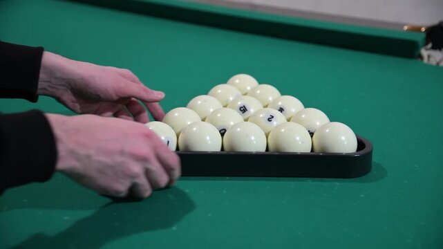 The beginning of a billiard game with the balls placed in a triangle and then hitting the loose