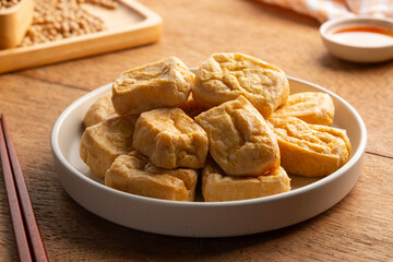 Crispy Air Fryer Tofu,Healthy cooked soybean block tofu used airfryer in white plate with chilli sweet sauce.