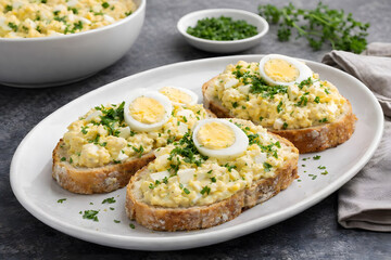 Delicious egg salad open faced sandwiches topped with fresh parsley and hard boiled eggs for homemade lunch