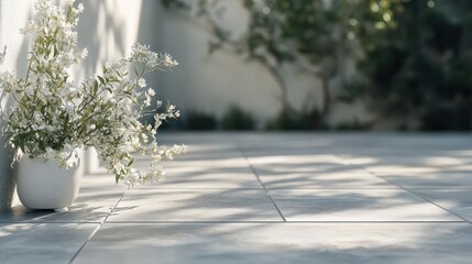 Smooth grey slate tiles arranged in a geometric mosaic pattern with soft sunlight and shadows casting across the textured surface