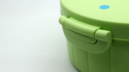 Green plastic lunch box on white background.