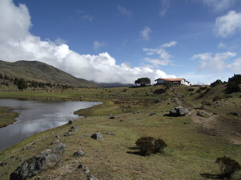 Paisaje rural en los Andes con monta&ntilde;as verdes, pinos y campos de cultivo, lagunas hermosas