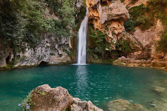 Young woman in bikini enjoying the crystal clear waters of La Calavera waterfall at Rio Borosa in Cazorla Natural Park Spain
