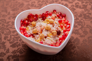 Chicken salad with pineapple and pomegranate in a heart shape