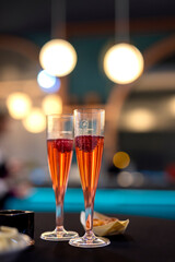 Two glasses of pink champagne on a table at a celebration. Happy new year and merry christmas