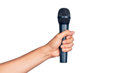 Hand holding a black microphone with a mesh head, fingers gripping the handle tightly, arm visible, isolated pure white background cutout