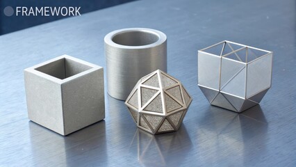 An arrangement of four modern geometric metal sculptures on a reflective surface