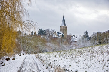 the catholic church of Ratingen Homberg in winter with snow-covered fields and country roads