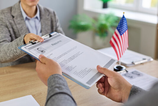 Consular visa interview with USA officer reviewing documents in public services or embassy. Immigration applicant answers questions and presents forms during a citizenship review seeking approval. 