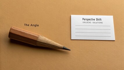 Wooden pencil poised next to a business card with 'Perspective Solves' text on a muted ochre surface