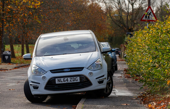 Milton Keynes,Bucks,UK -Nov. 8th 2025: Line of cars parked on the pavement next to a road sign warning of frail and elderly pedestrians.