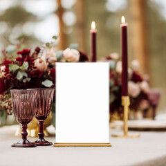 Elegant table setup with table sign mockup, burgundy candles and floral arrangements