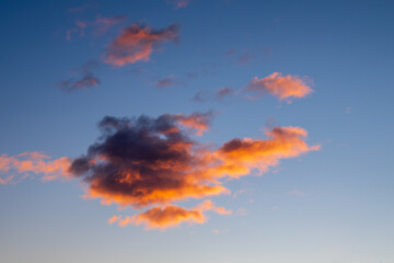 A glowing cloud at sunrise against a blue sky