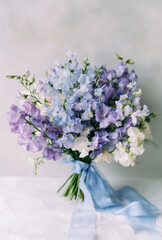 Delicate bouquet of blue and purple wildflowers tied with a blue ribbon