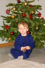 Toddler Sitting Before Decorated Christmas Tree