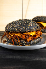 Vegan pulled mushroom burger with black bun on dark background