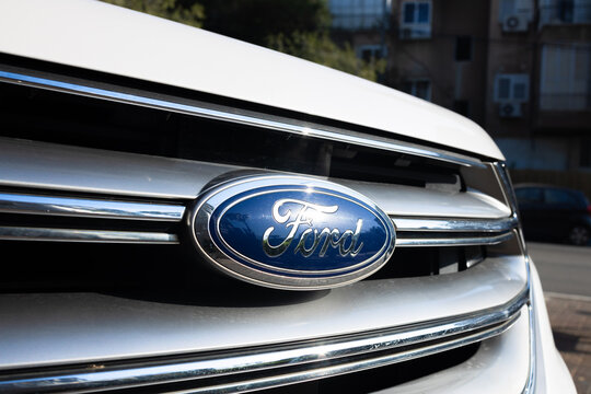 Close-up of the blue Ford emblem on a silver radiator grille of a white car, Givatayim, Israel, 04 December, 2025